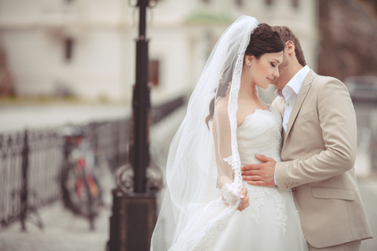 Bride and groom at wedding day kissing at park _59322440_XS